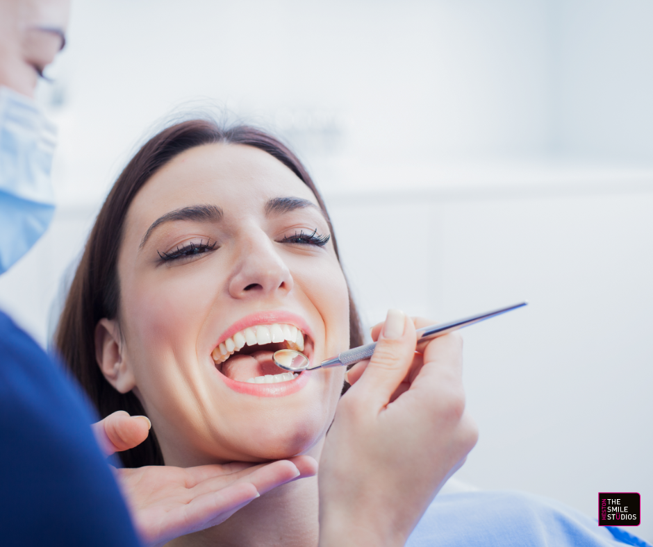 Close up of a young female adult having her teeth checked over. She is smiling. 