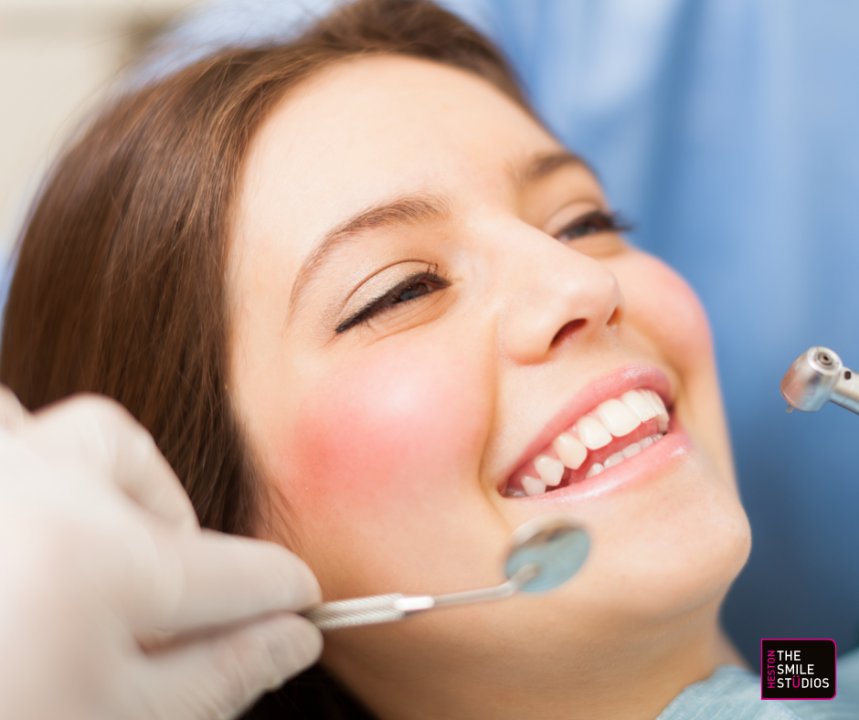 Close up of a young female adult smiling in the dentist's chair.